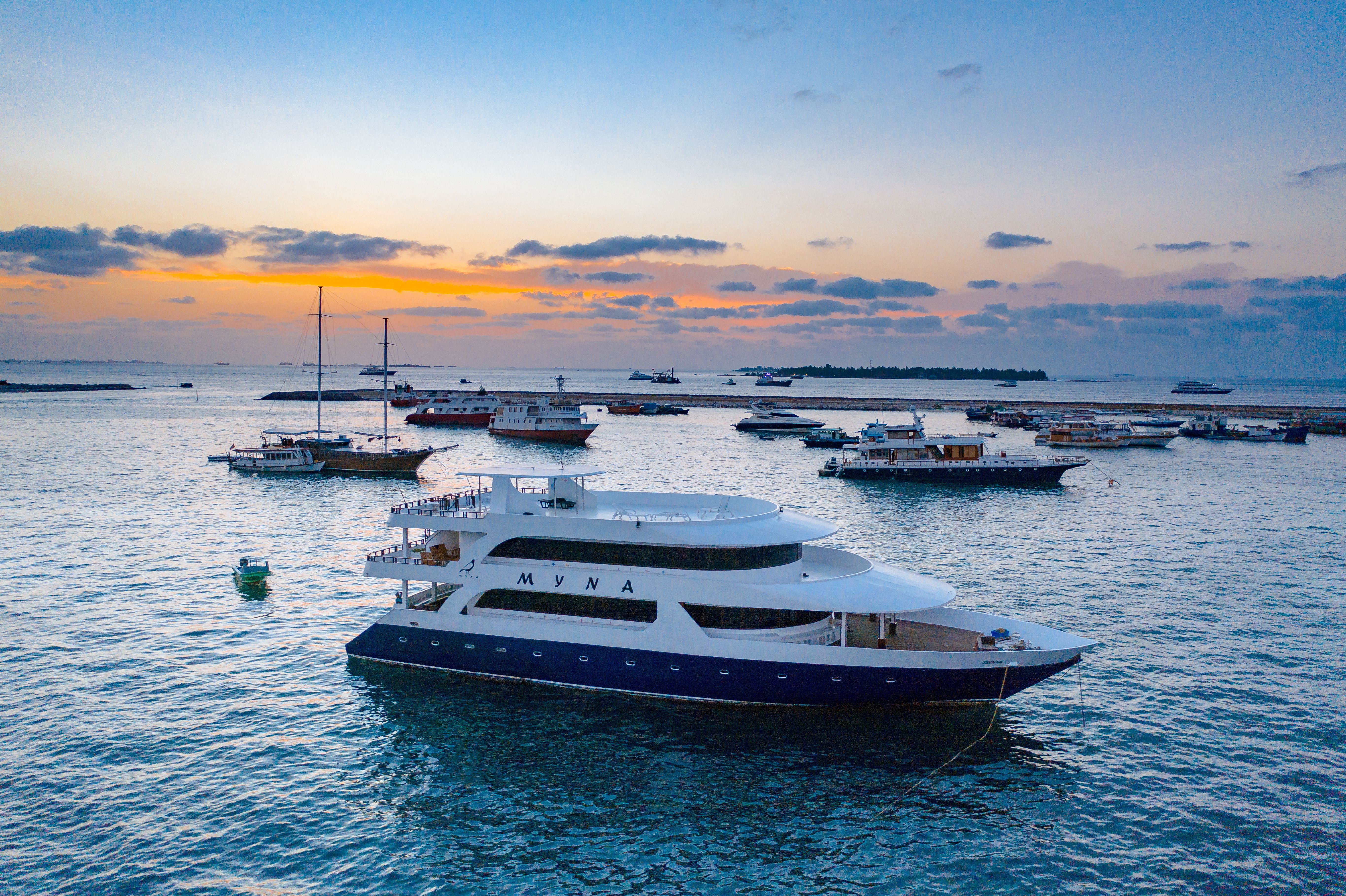 Luxury yacht cruising Karnataka's coastline at sunset